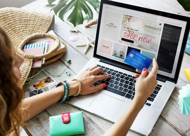 A member shopping online with a card in hand